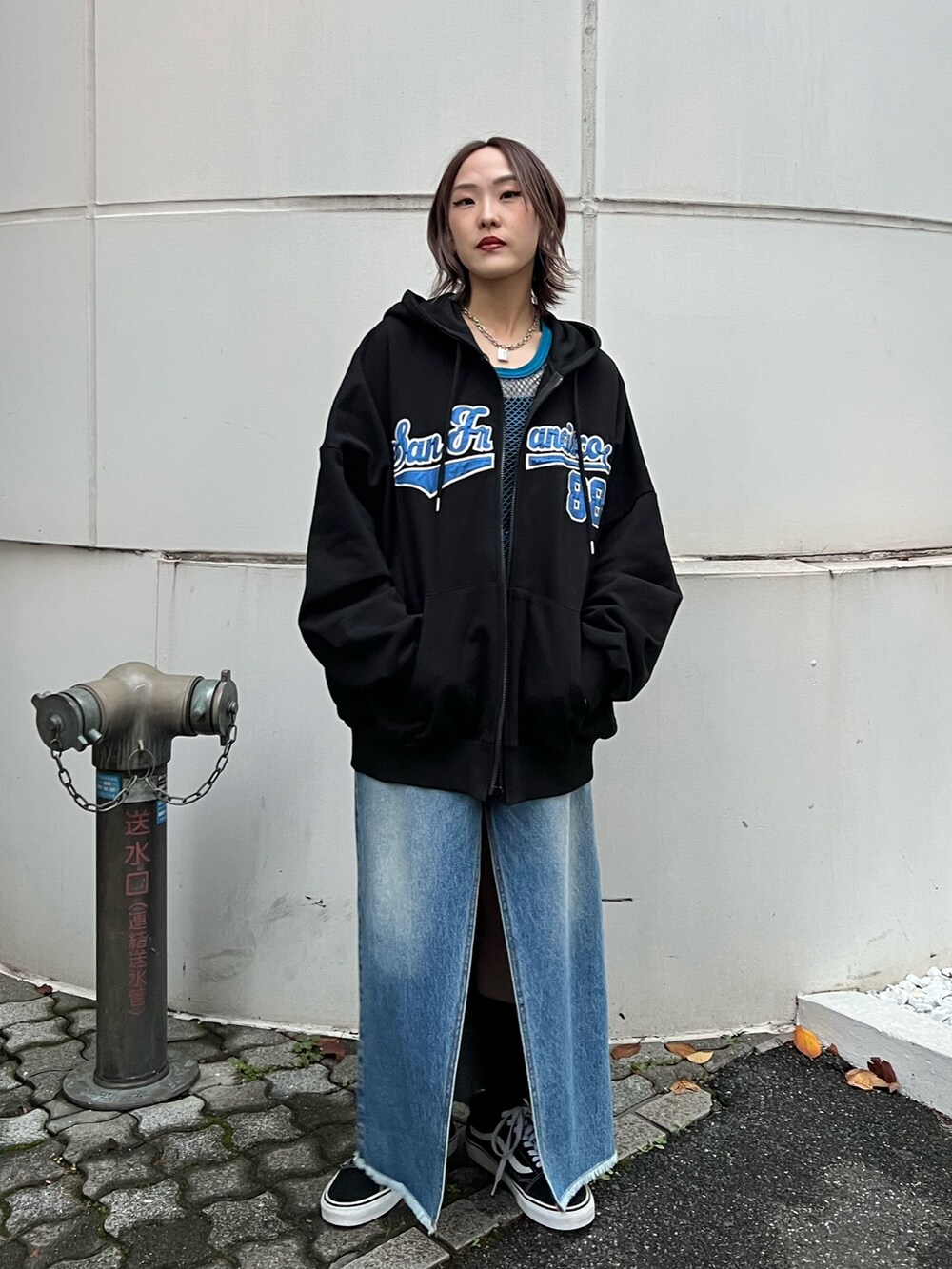 ブルー系のスカート、ブラック系のパーカー、ブルー系のタンクトップを着用したレディースの春コーディネートの2枚目の写真