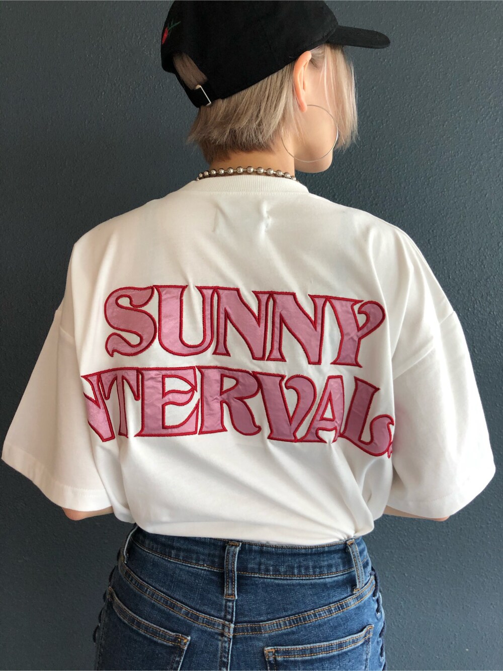 ブルー系のデニムパンツ、ピンク系のワンピース、ホワイト系のサンダルを着用したレディースの春コーディネートの9枚目の写真