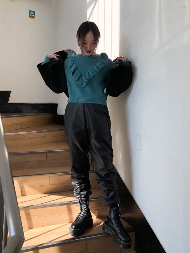 ブラック系のその他パンツ、ブラック系のミリタリージャケット、ブルー系のニット/セーターを着用したレディースの冬コーディネートの5枚目の写真