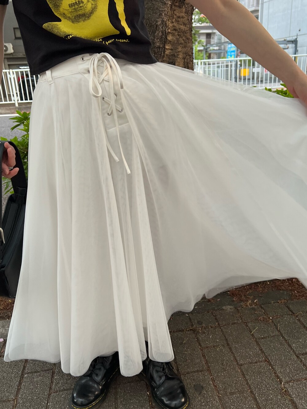 ブラック系のTシャツ/カットソー、ホワイト系のスカート、ブラック系のハンドバッグを着用したレディースの夏コーディネートの7枚目の写真