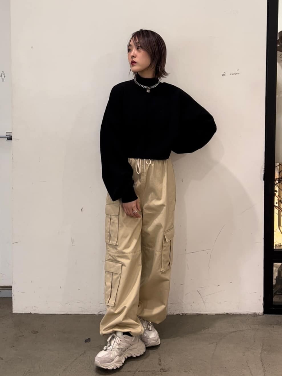 パープル系のカーディガン/ボレロ、ホワイト系のカーゴパンツ、ブラック系のスウェットを着用したレディースの秋コーディネートの2枚目の写真
