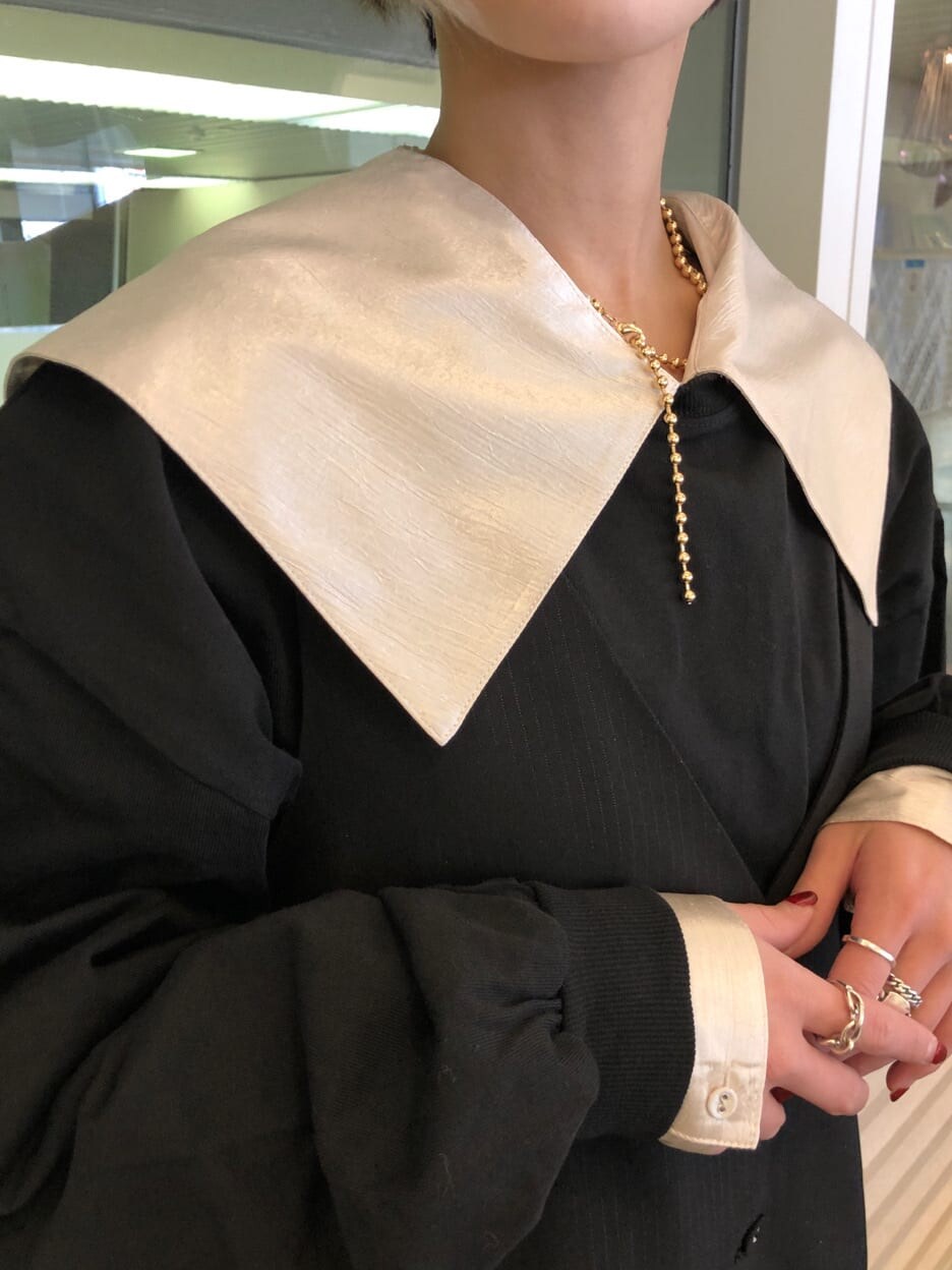 ホワイト系のシャツ/ブラウス、ブラック系のジャンパースカート、ホワイト系のブーツを着用したレディースの春コーディネートの4枚目の写真