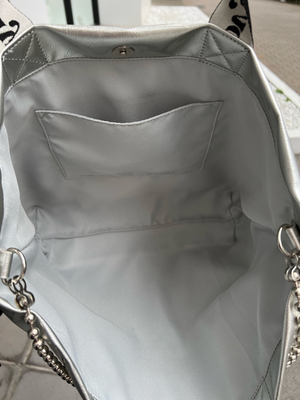 シルバー系のトートバッグ、ブラック系のシャツ/ブラウス、ブラック系のワンピースを着用したレディースの春コーディネートの9枚目の写真