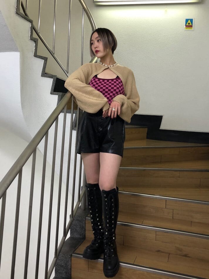 ベージュ系のトレンチコート、ブラック系のその他パンツ、ブラック系のブーツを着用したレディースの春コーディネートの4枚目の写真