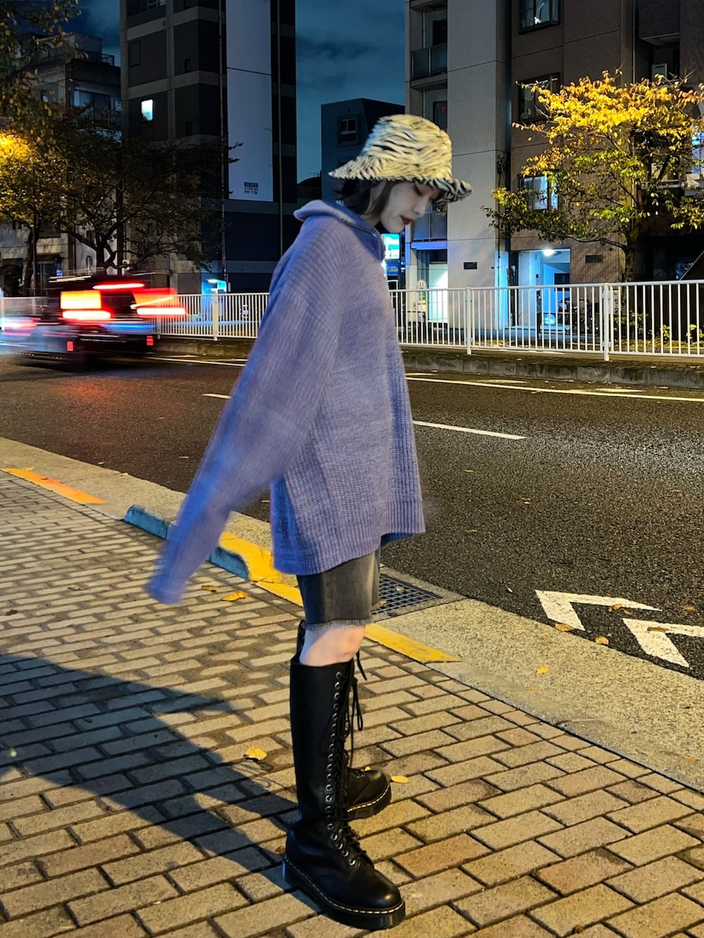 パープル系のニット/セーター、ブラック系のデニムパンツ、ホワイト系のハットを着用したレディースの冬コーディネートの4枚目の写真