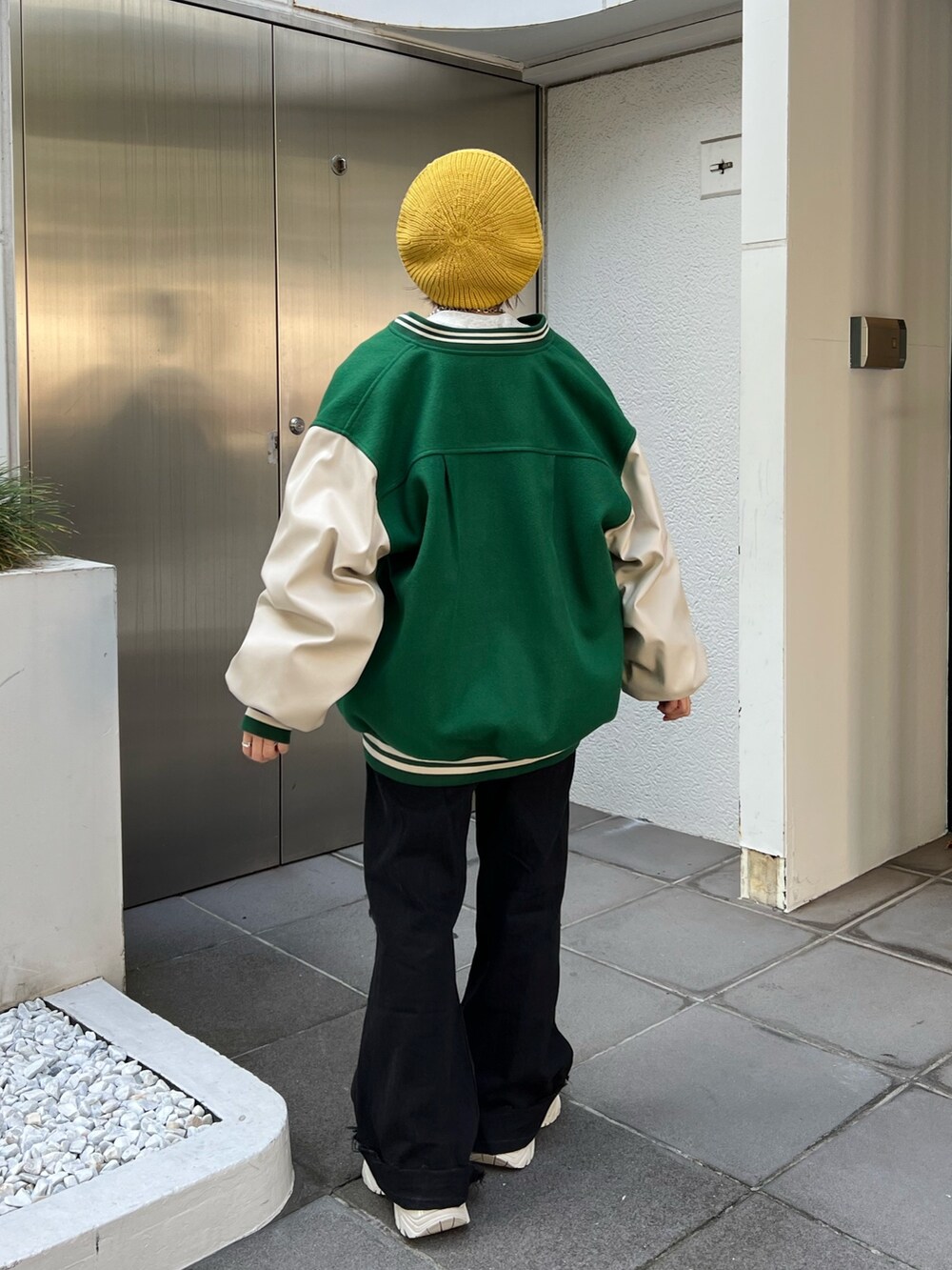 グレー系のスウェット、グリーン系のスタジャン、ホワイト系のスニーカーを着用したレディースの秋コーディネートの3枚目の写真