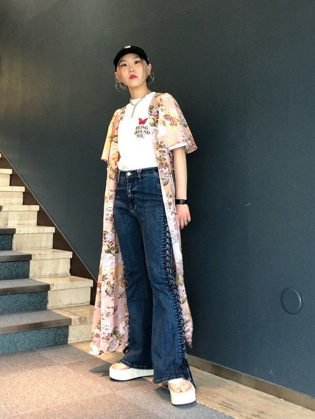 ブルー系のデニムパンツ、ピンク系のワンピース、ホワイト系のサンダルを着用したレディースの春コーディネートの2枚目の写真