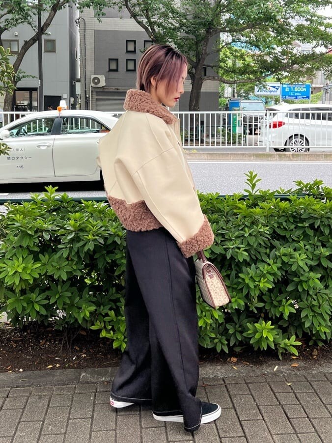 ブラウン系のハンドバッグ、ホワイト系のTシャツ/カットソー、ブラック系のその他パンツを着用したレディースの秋コーディネートの5枚目の写真