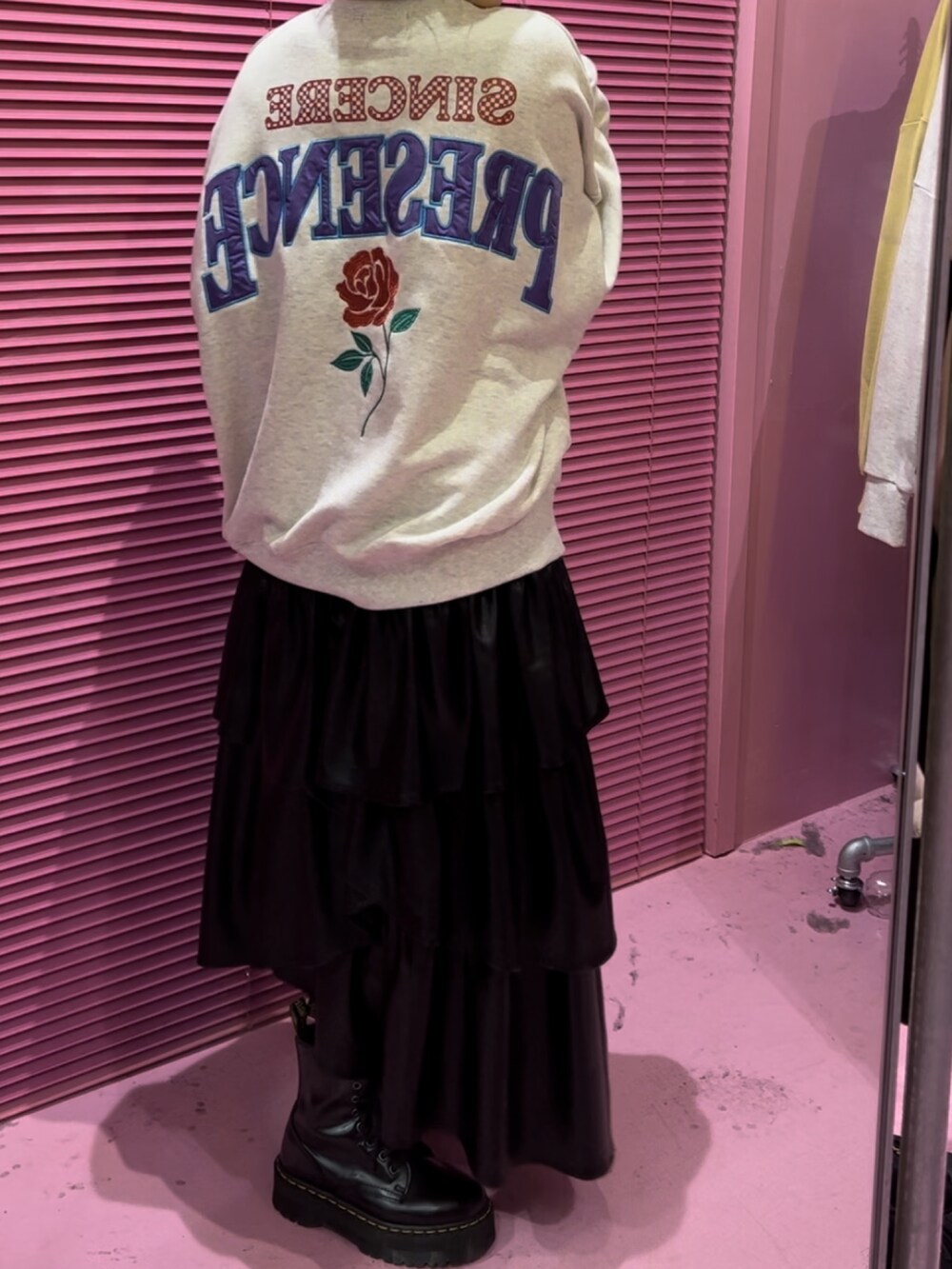 グレー系のTシャツ/カットソー、ブラック系のスカート、ブラック系のブーツを着用したレディースの秋コーディネートの4枚目の写真