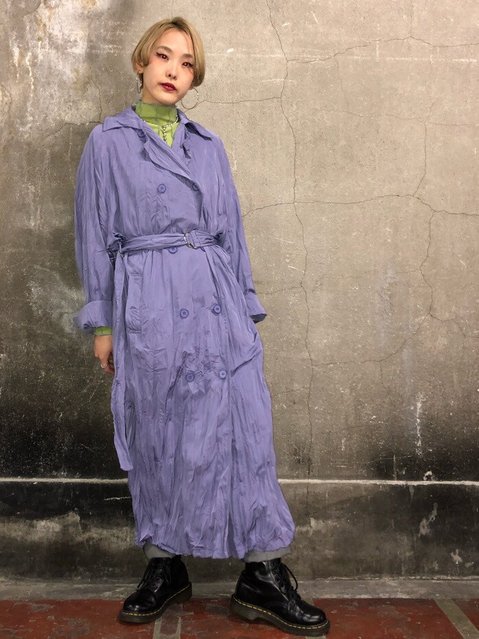 ブラック系のデニムパンツ、グリーン系のTシャツ/カットソー、パープル系のトレンチコートを着用したレディースの冬コーディネートの2枚目の写真