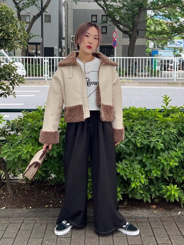 ブラウン系のハンドバッグ、ホワイト系のTシャツ/カットソー、ブラック系のその他パンツを着用したレディースの秋コーディネートの3枚目の写真