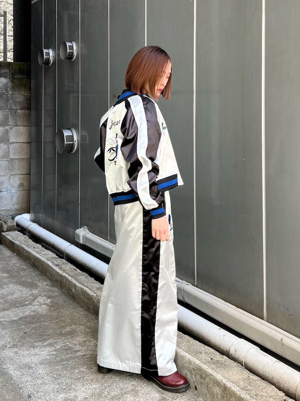 ホワイト系のスカジャン、ホワイト系のスカート、ブラック系のシャツ/ブラウスを着用したレディースの冬コーディネートの3枚目の写真