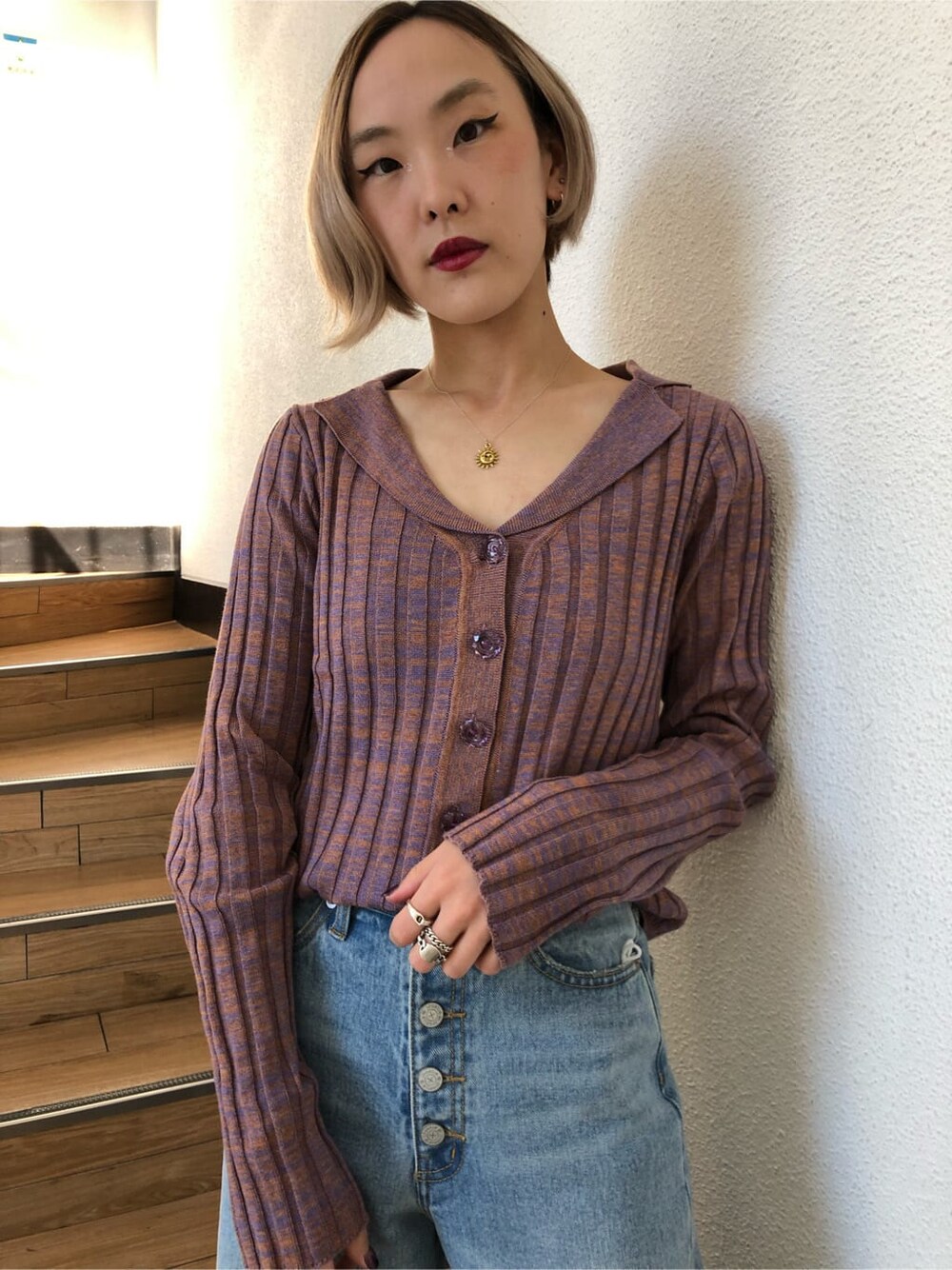 ブルー系のデニムパンツ、パープル系のニット/セーターを着用したレディースの冬コーディネートの3枚目の写真