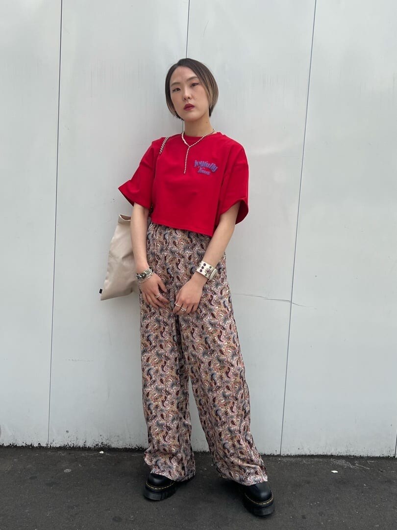 ホワイト系のトートバッグ、ブラック系のその他シューズ、レッド系のTシャツ/カットソーを着用したレディースの春コーディネートの2枚目の写真