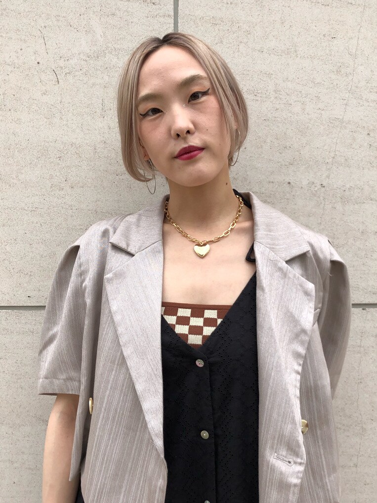 レッド系のブーツ、ホワイト系のセットアップ、ブラック系のワンピースを着用したレディースの春コーディネートの5枚目の写真