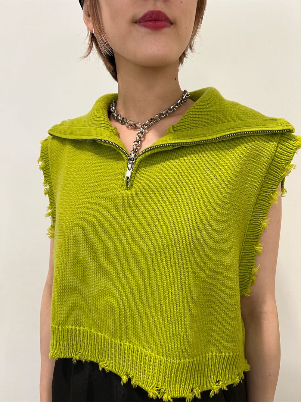 ホワイト系のローファー、グリーン系のベスト、ブラック系のジャンパースカートを着用したレディースの秋コーディネートの9枚目の写真