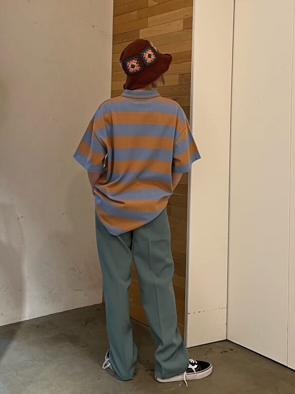 ブルー系のスラックス、グリーン系のハンドバッグ、ブルー系のTシャツ/カットソーを着用したレディースの夏コーディネートの3枚目の写真