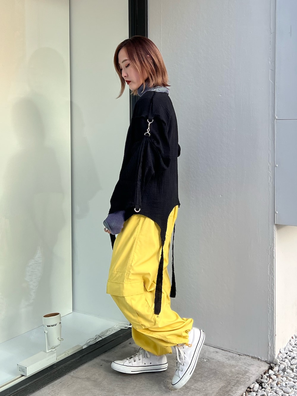 イエロー系のその他パンツ、パープル系のニット/セーター、ブラック系のシャツ/ブラウスを着用したレディースの冬コーディネートの2枚目の写真