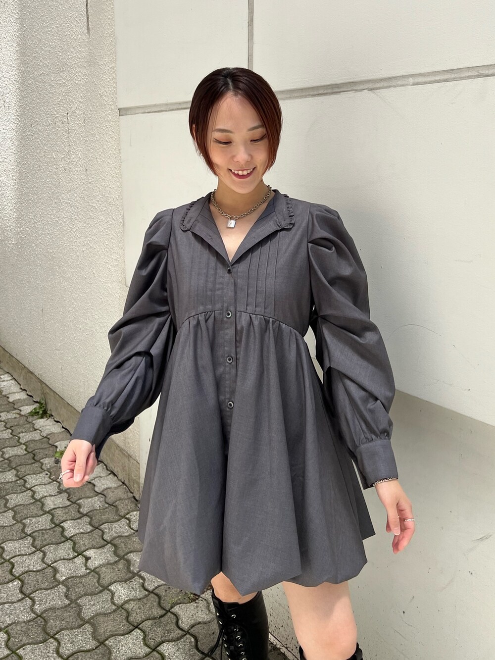 グレー系のワンピース、ブラック系のブーツを着用したレディースの夏コーディネートの5枚目の写真