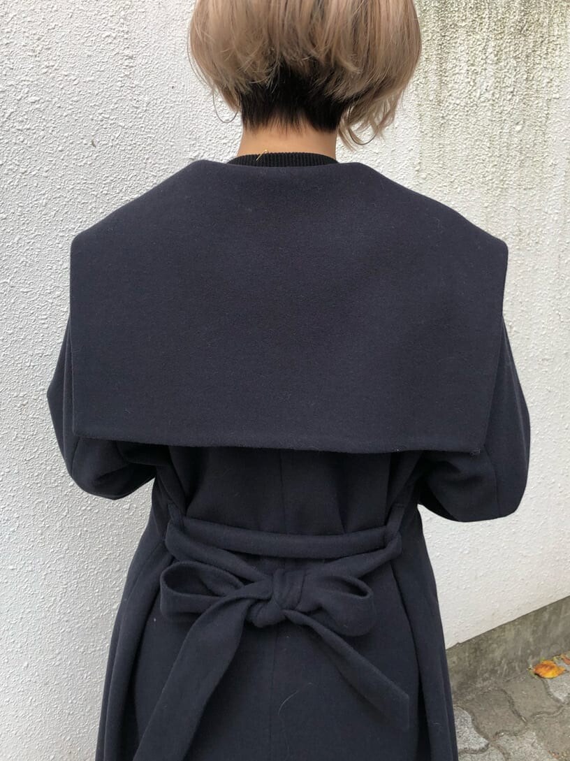 ブルー系のチェスターコート、ブラック系のデニムパンツ、ブラック系のニット/セーターを着用したレディースの秋コーディネートの7枚目の写真