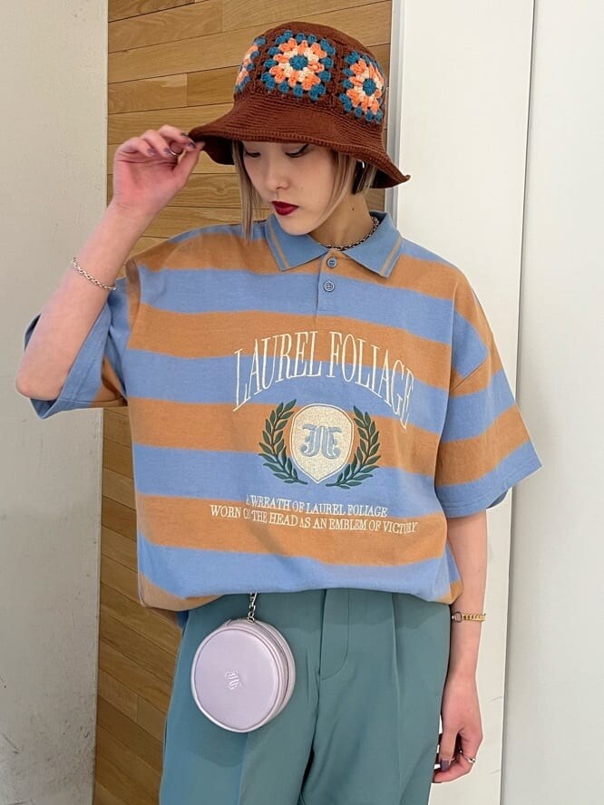 ブルー系のスラックス、グリーン系のハンドバッグ、ブルー系のTシャツ/カットソーを着用したレディースの夏コーディネートの5枚目の写真