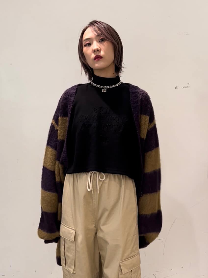 パープル系のカーディガン/ボレロ、ホワイト系のカーゴパンツ、ブラック系のスウェットを着用したレディースの秋コーディネートの6枚目の写真