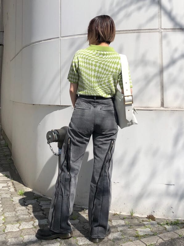 グリーン系のニット/セーター、ブラック系のデニムパンツ、ホワイト系のハンドバッグを着用したレディースの夏コーディネートの9枚目の写真