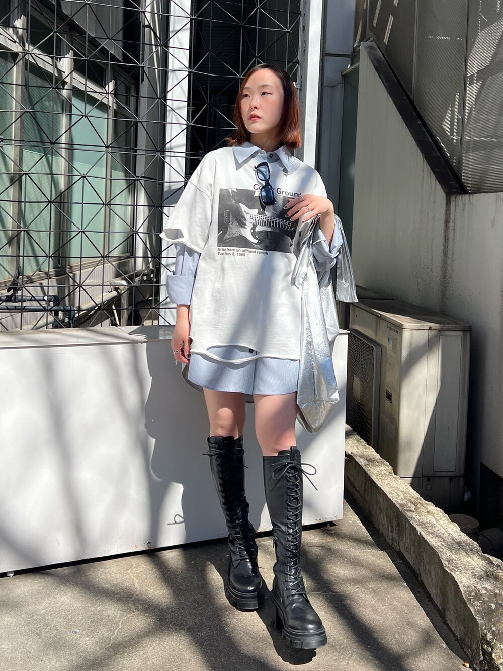 シルバー系のトートバッグ、ブルー系のシャツ/ブラウス、ホワイト系のTシャツ/カットソーを着用したレディースの春コーディネートの3枚目の写真