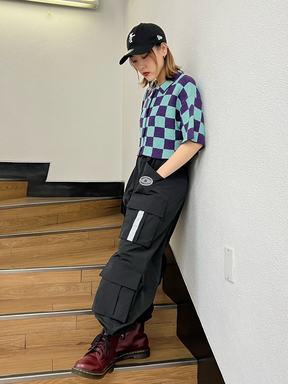 ブラック系のカーゴパンツ、パープル系のカーディガン/ボレロ、ブラック系のキャップを着用したレディースの春コーディネートの2枚目の写真