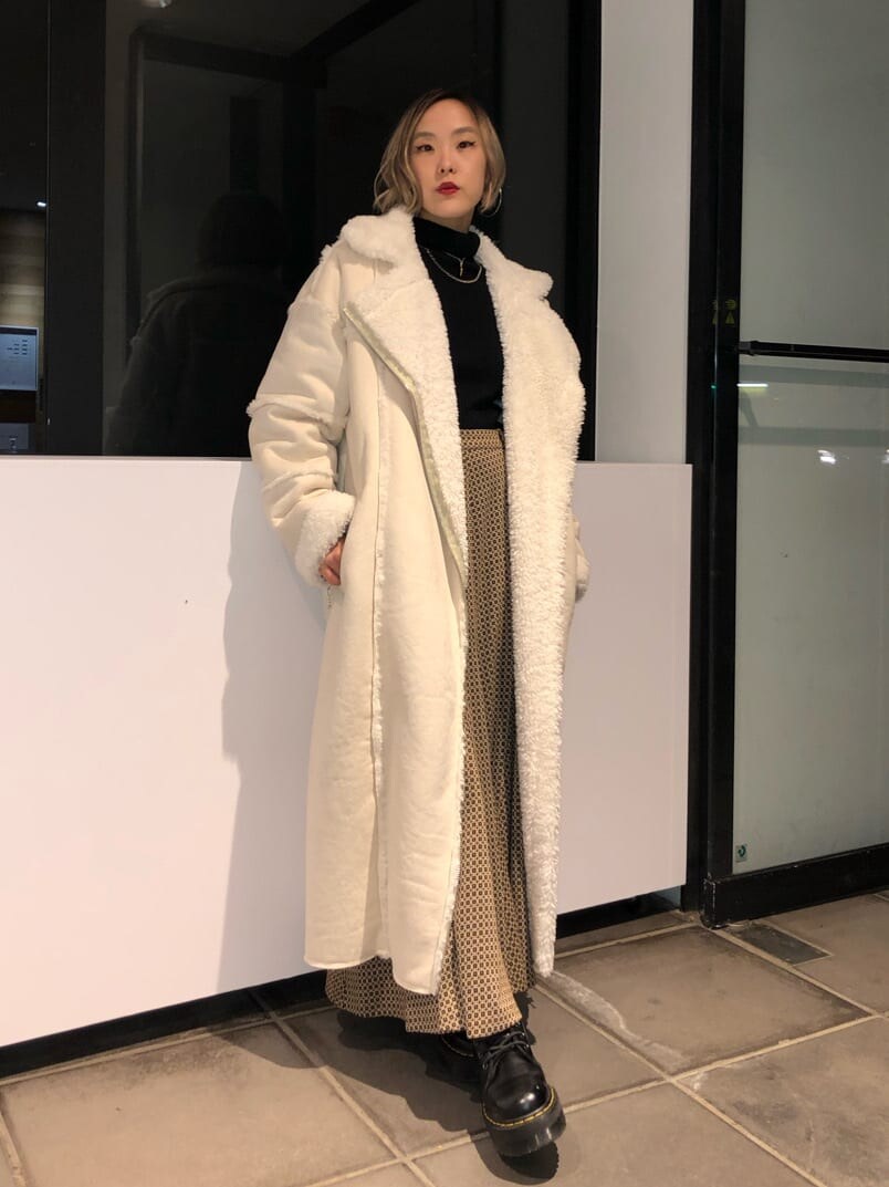 ホワイト系のムートンコート、その他のスカート、ブラック系のカーディガン/ボレロを着用したレディースの秋コーディネートの2枚目の写真