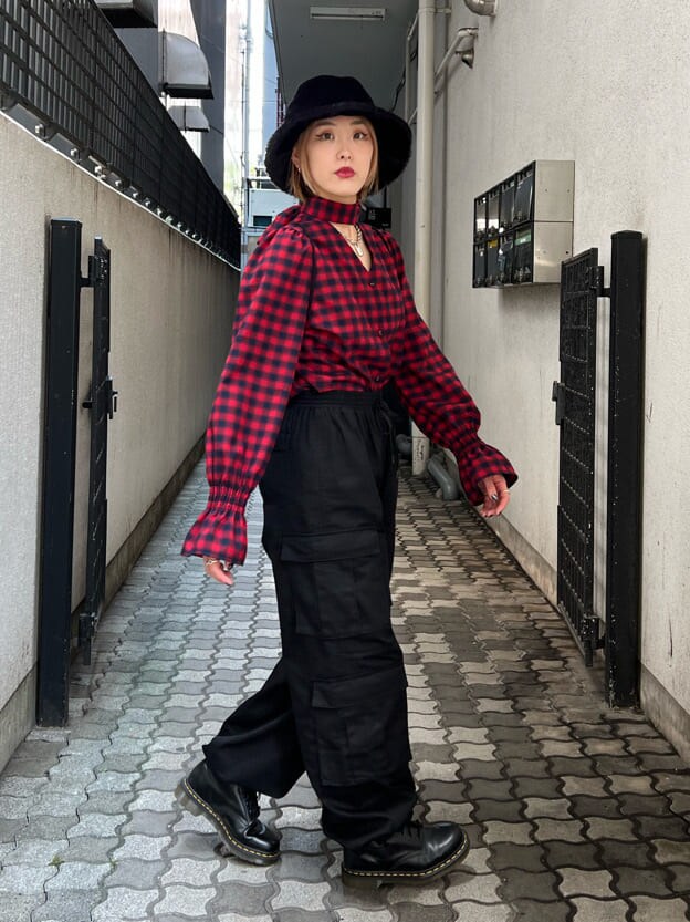 ブラック系のバックパック/リュック、レッド系のシャツ/ブラウス、ブラック系のカーゴパンツを着用したレディースの秋コーディネートの3枚目の写真