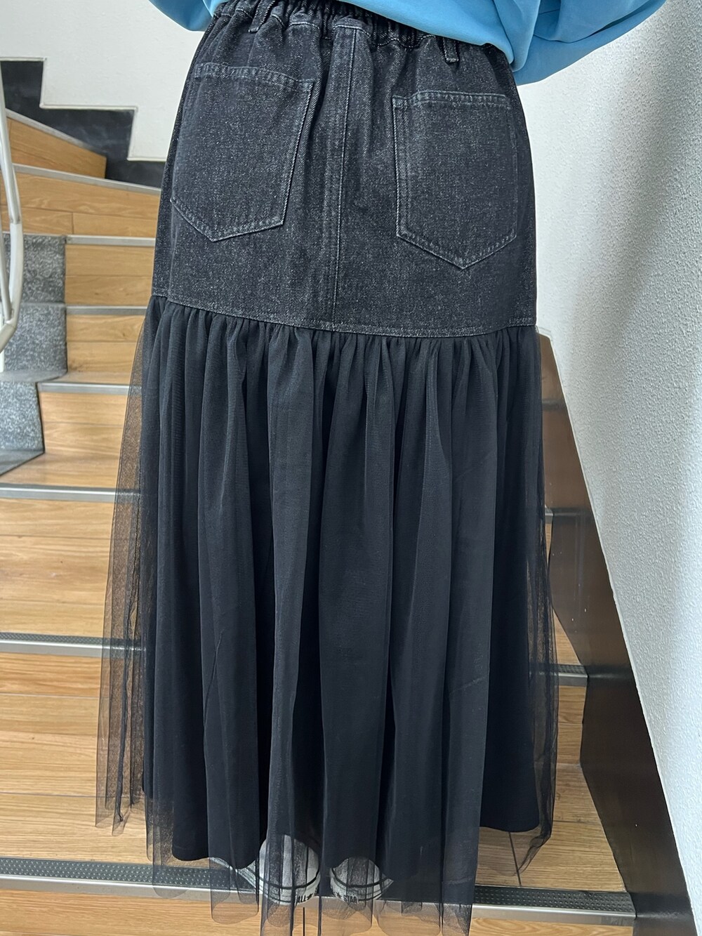 ブルー系のスウェット、ブラック系のスカート、グレー系のトートバッグを着用したレディースの冬コーディネートの9枚目の写真