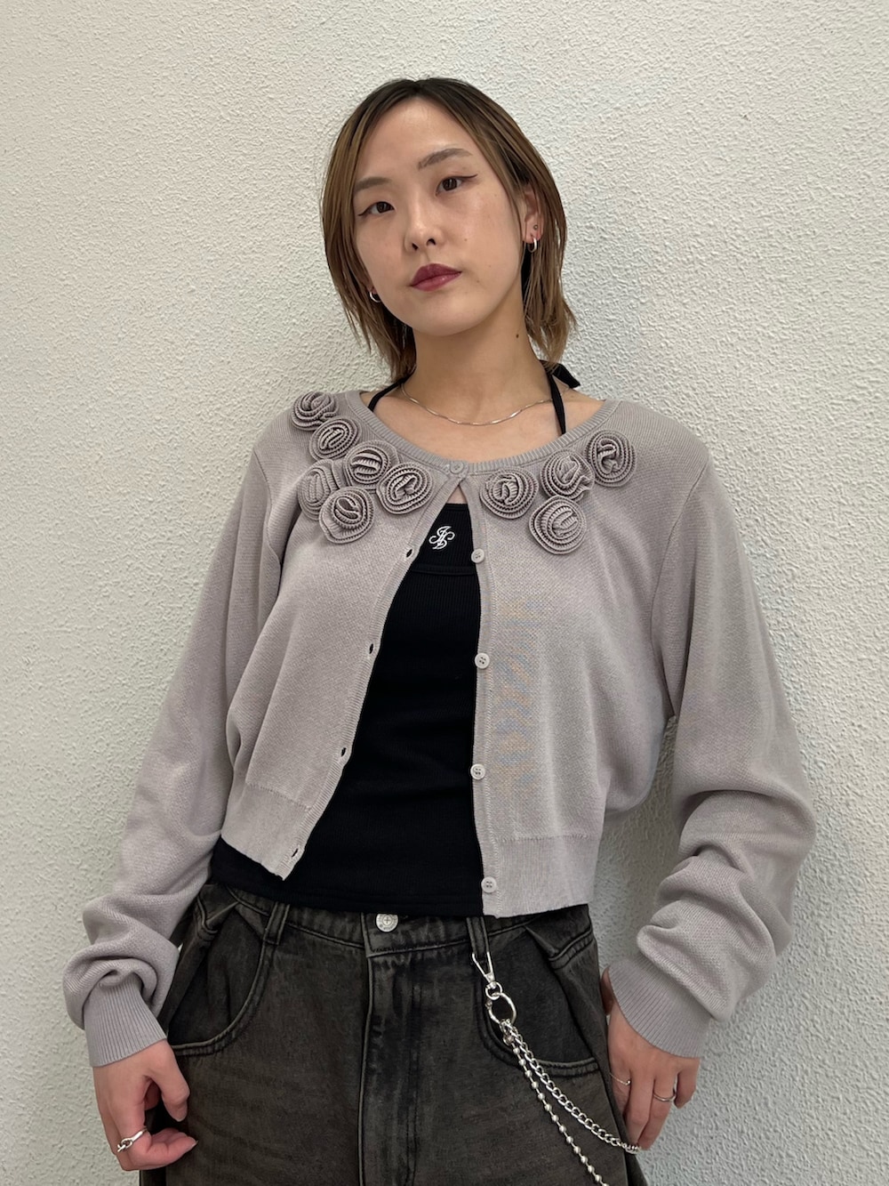 グレー系のニット/セーター、ブラック系のキャミソール、ブラック系のデニムパンツを着用したレディースの春コーディネートの6枚目の写真