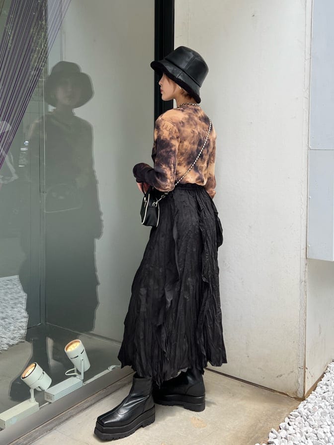 ブラック系のワンピース、ブラック系のTシャツ/カットソー、ブラック系のブーツを着用したレディースの秋コーディネートの3枚目の写真