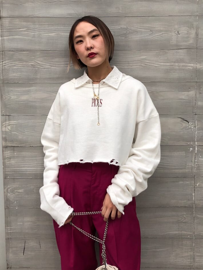 ピンク系のスラックス、ホワイト系のトートバッグ、ブラック系のブーツを着用したレディースの春コーディネートの6枚目の写真