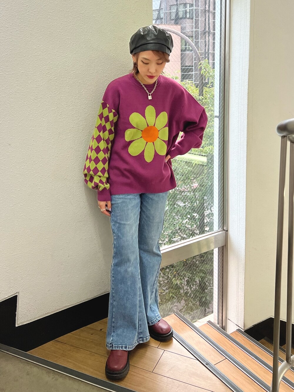 パープル系のニット/セーター、ブルー系のデニムパンツ、レッド系のブーツを着用したレディースの秋コーディネートの2枚目の写真