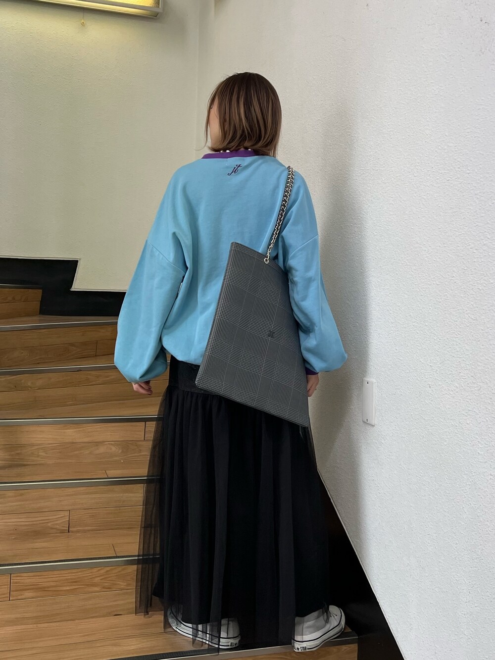 ブルー系のスウェット、ブラック系のスカート、グレー系のトートバッグを着用したレディースの冬コーディネートの3枚目の写真