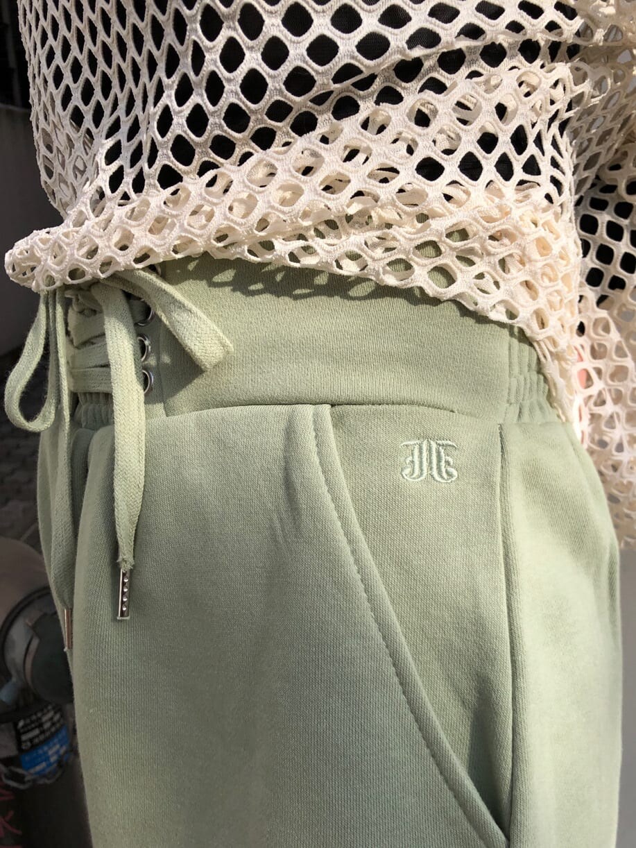 グリーン系のスウェットパンツ、ホワイト系のTシャツ/カットソー、ブラック系のニットキャップ/ビーニーを着用したレディースの冬コーディネートの5枚目の写真