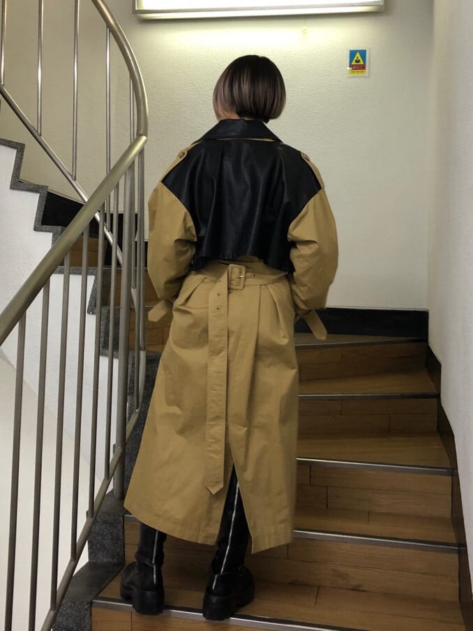 ベージュ系のトレンチコート、ブラック系のその他パンツ、ブラック系のブーツを着用したレディースの春コーディネートの3枚目の写真