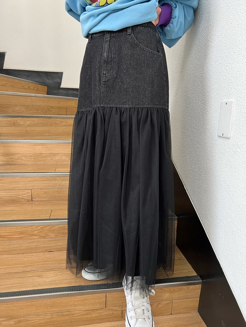 ブルー系のスウェット、ブラック系のスカート、グレー系のトートバッグを着用したレディースの冬コーディネートの8枚目の写真