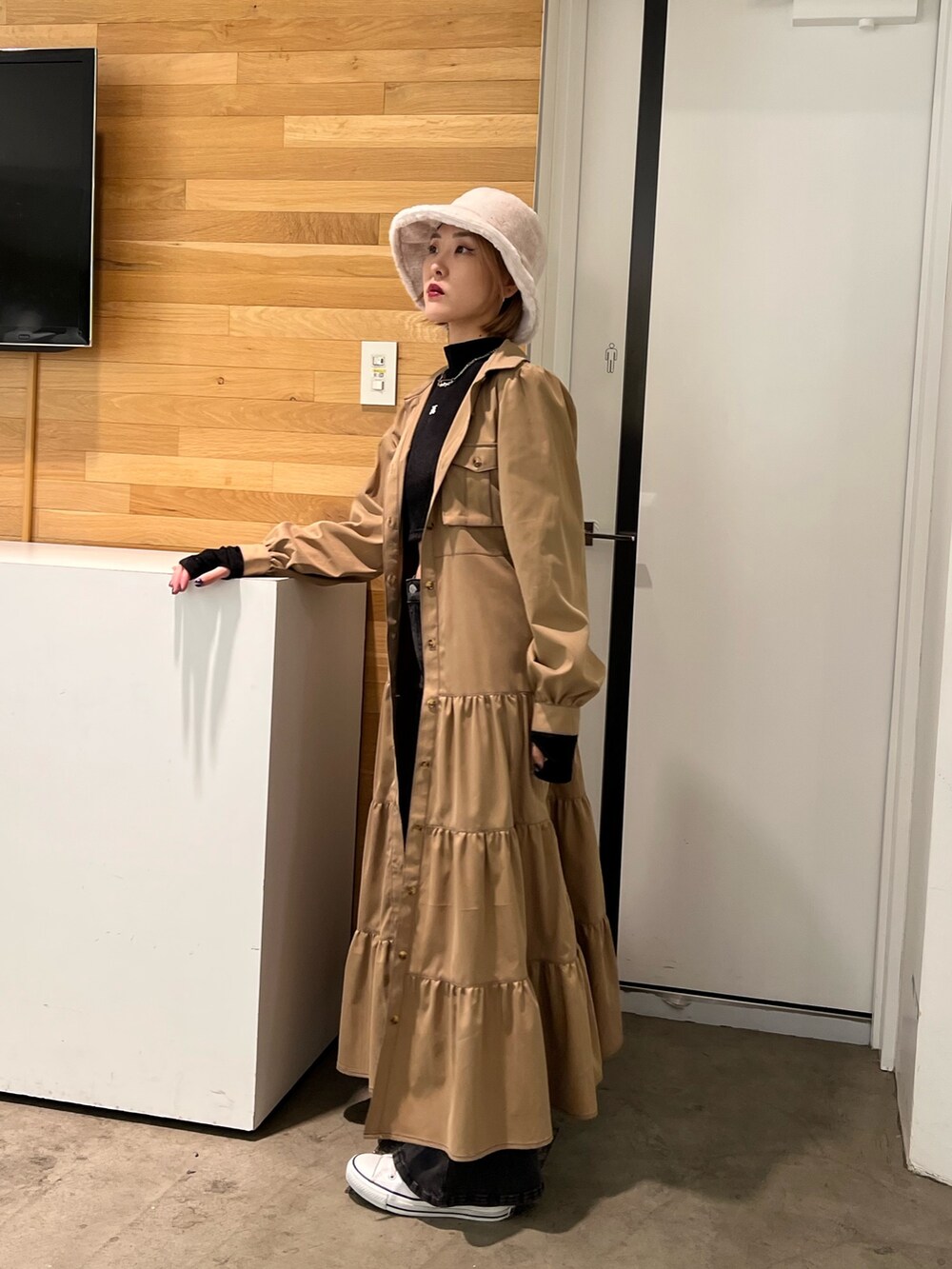 ブラック系のデニムパンツ、ブラック系のTシャツ/カットソー、ベージュ系のワンピースを着用したレディースの秋コーディネートの2枚目の写真