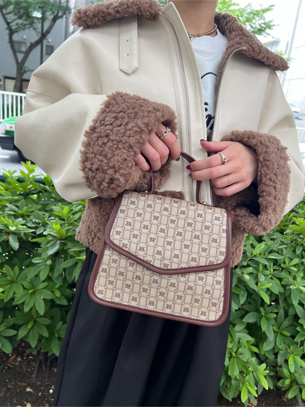 ブラウン系のハンドバッグ、ホワイト系のTシャツ/カットソー、ブラック系のその他パンツを着用したレディースの秋コーディネートの10枚目の写真