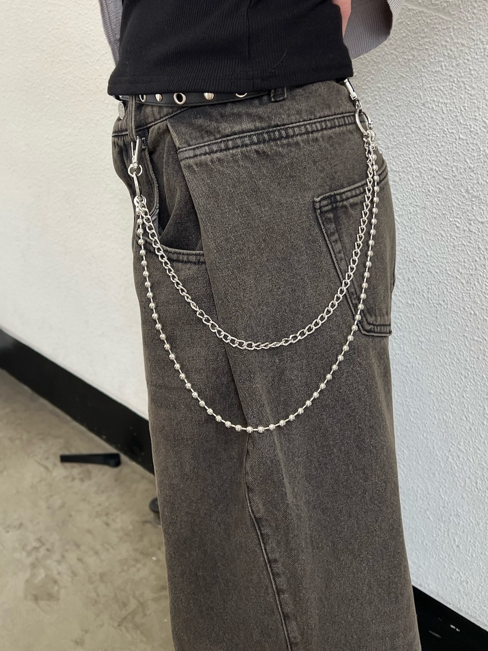 グレー系のニット/セーター、ブラック系のキャミソール、ブラック系のデニムパンツを着用したレディースの春コーディネートの7枚目の写真