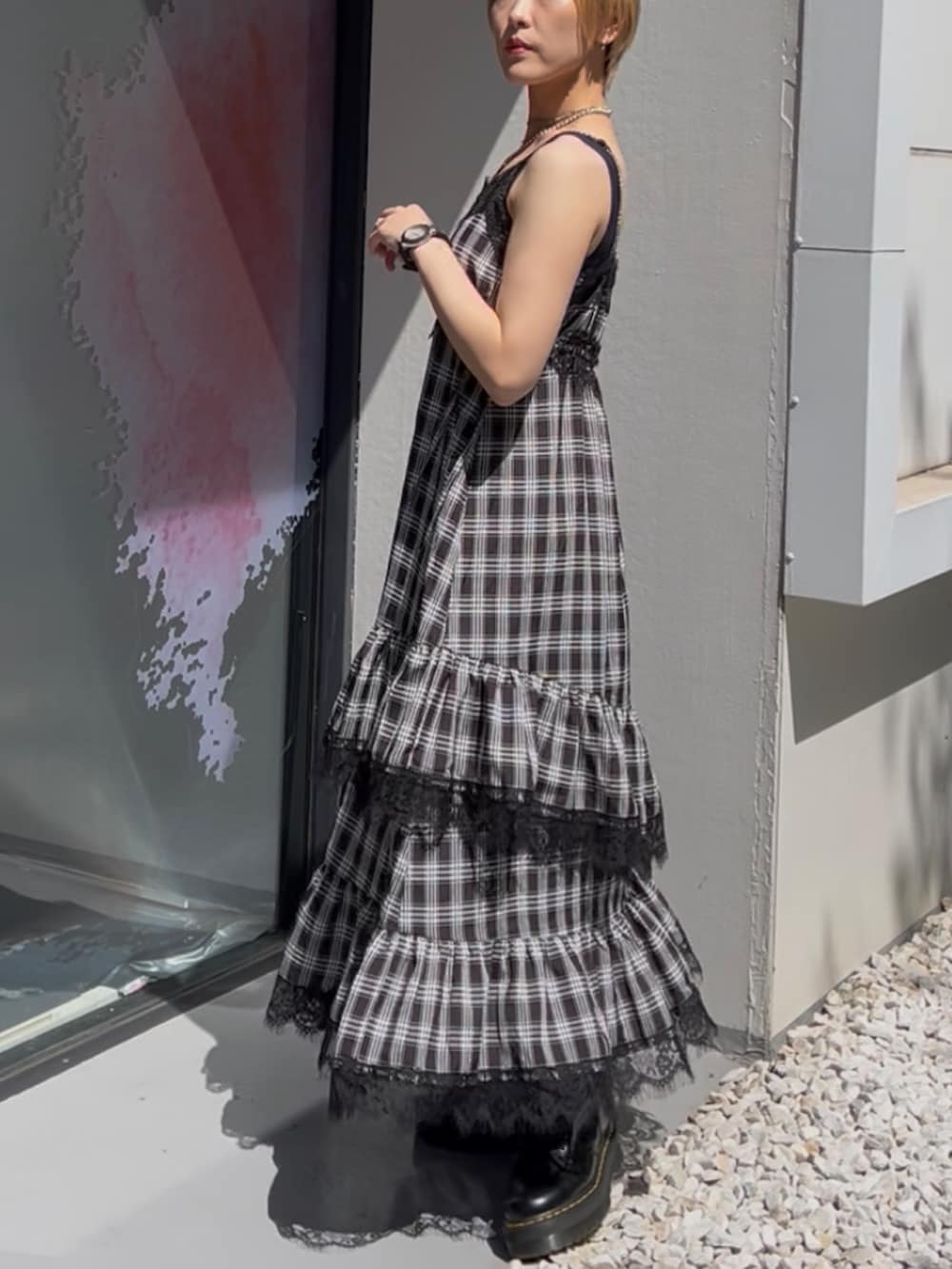 ブラック系のワンピース、ホワイト系のブルゾン、ブラック系のブーツを着用したレディースの夏コーディネートの5枚目の写真