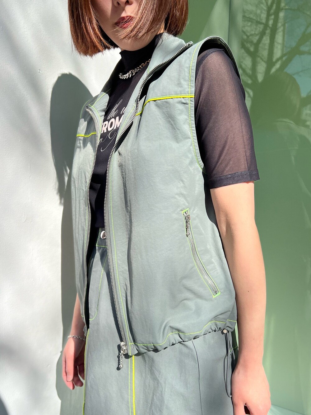 ブラック系のTシャツ/カットソー、グレー系のベスト、グレー系のスカートを着用したレディースの冬コーディネートの6枚目の写真