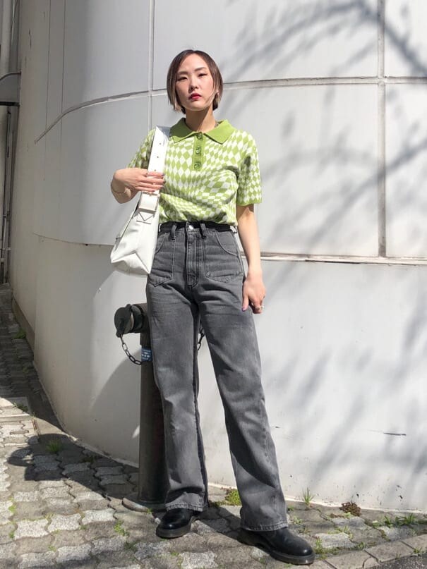 グリーン系のニット/セーター、ブラック系のデニムパンツ、ホワイト系のハンドバッグを着用したレディースの夏コーディネートの8枚目の写真