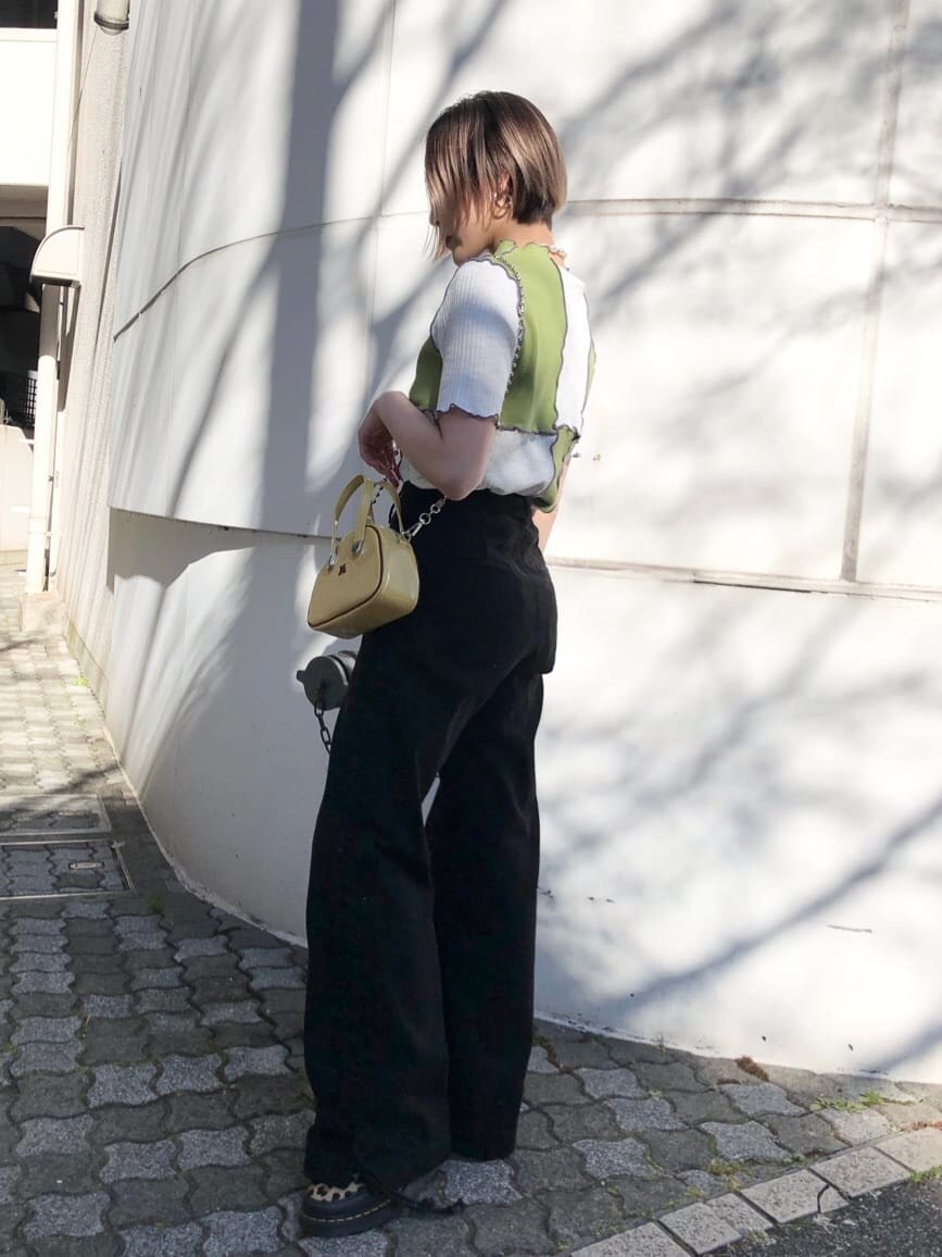 イエロー系のボストンバッグ、ブラック系のデニムパンツ、グリーン系のTシャツ/カットソーを着用したレディースの夏コーディネートの5枚目の写真