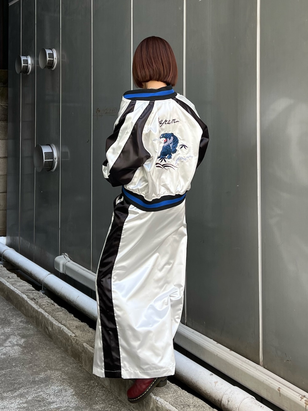 ホワイト系のスカジャン、ホワイト系のスカート、ブラック系のシャツ/ブラウスを着用したレディースの冬コーディネートの2枚目の写真