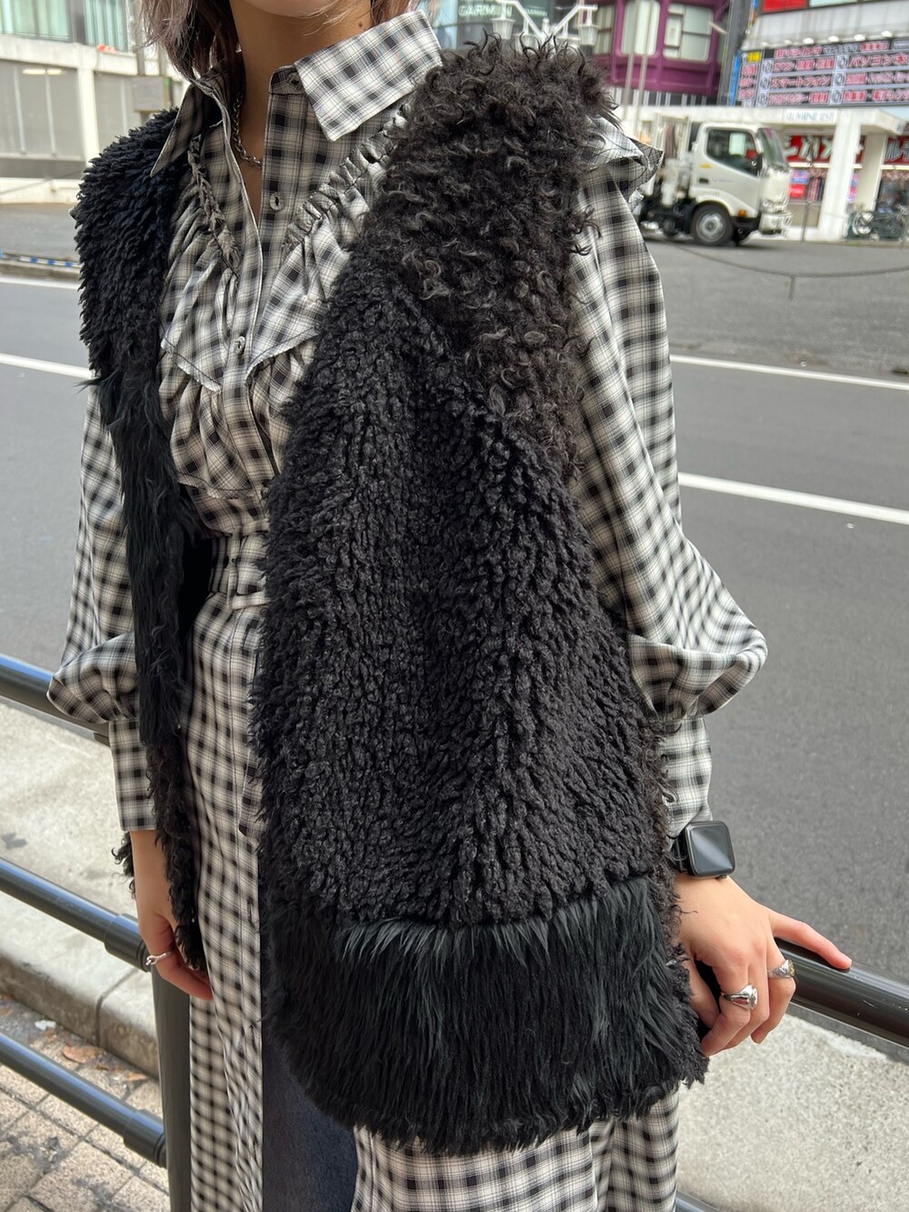 ブラック系のワンピース、ブラック系のベスト、ブルー系のデニムパンツを着用したレディースの冬コーディネートの7枚目の写真