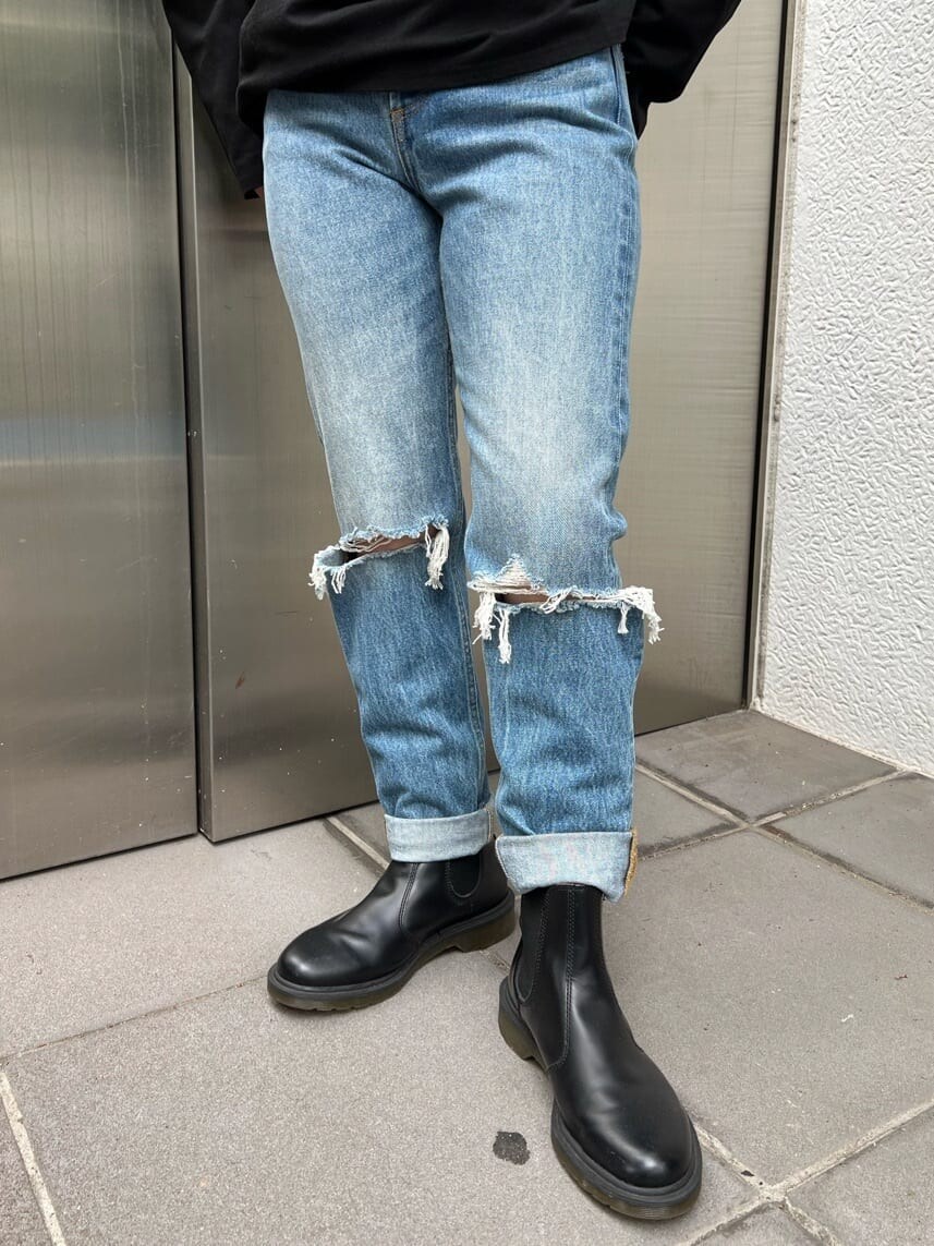 ブルー系のデニムパンツ、ホワイト系のハンドバッグ、パープル系のTシャツ/カットソーを着用したレディースの夏コーディネートの9枚目の写真